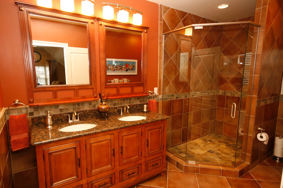 ワシントンD.C.にある広いトラディショナルスタイルのおしゃれなマスターバスルーム (中間色木目調キャビネット、コーナー設置型シャワー、赤い壁、セラミックタイルの床、オーバーカウンターシンク、御影石の洗面台) の写真