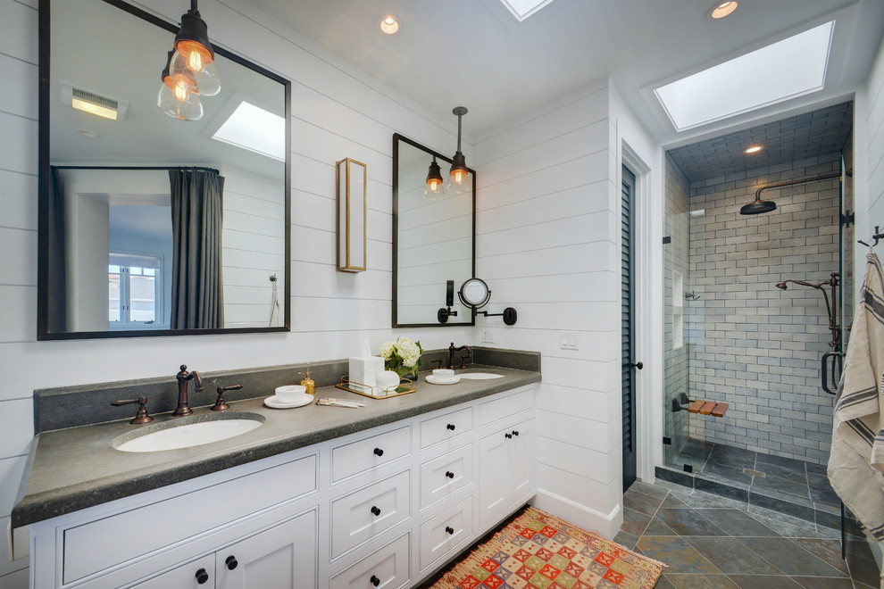 Inspiration for a beach style shower room bathroom in Los Angeles with shaker cabinets, white cabinets, an alcove shower, beige tiles, grey tiles, metro tiles, white walls, a submerged sink, grey floors, a hinged door and grey worktops.