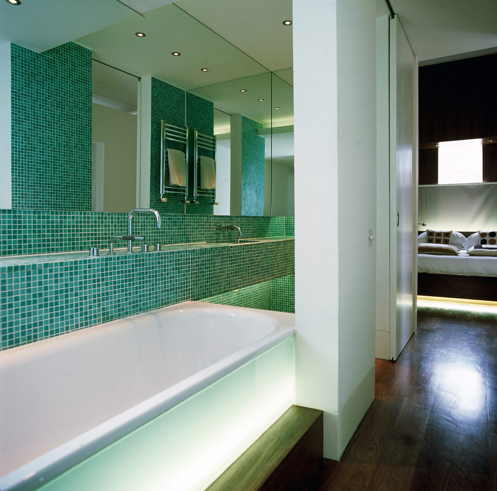 Inspiration for a small contemporary ensuite bathroom in London with glass-front cabinets, tiled worktops, a built-in bath, a built-in shower, green tiles, mosaic tiles, white walls and medium hardwood flooring.