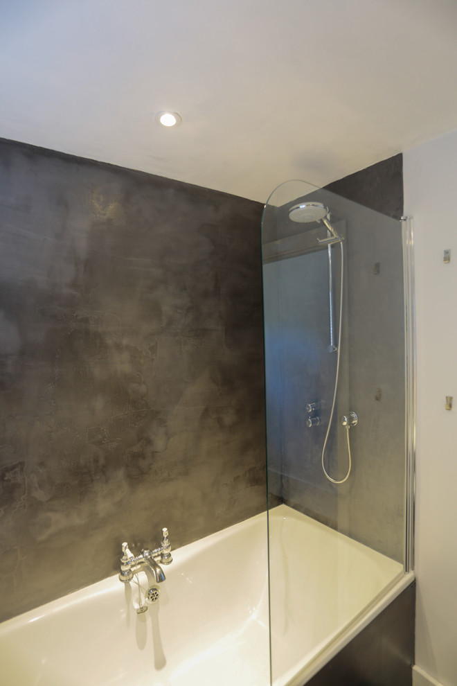 Exempel på ett mellanstort klassiskt badrum för barn, med ett platsbyggt badkar, en dusch/badkar-kombination, grå kakel, cementkakel, grå väggar, målat trägolv och bänkskiva i betong