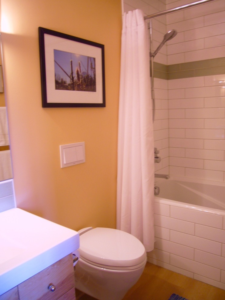 Idées déco pour une salle de bain principale contemporaine en bois clair avec un placard à porte plane, une baignoire posée, un combiné douche/baignoire, WC à poser, un carrelage blanc, des carreaux de porcelaine, un mur beige, un sol en vinyl, un lavabo intégré et un plan de toilette en quartz.