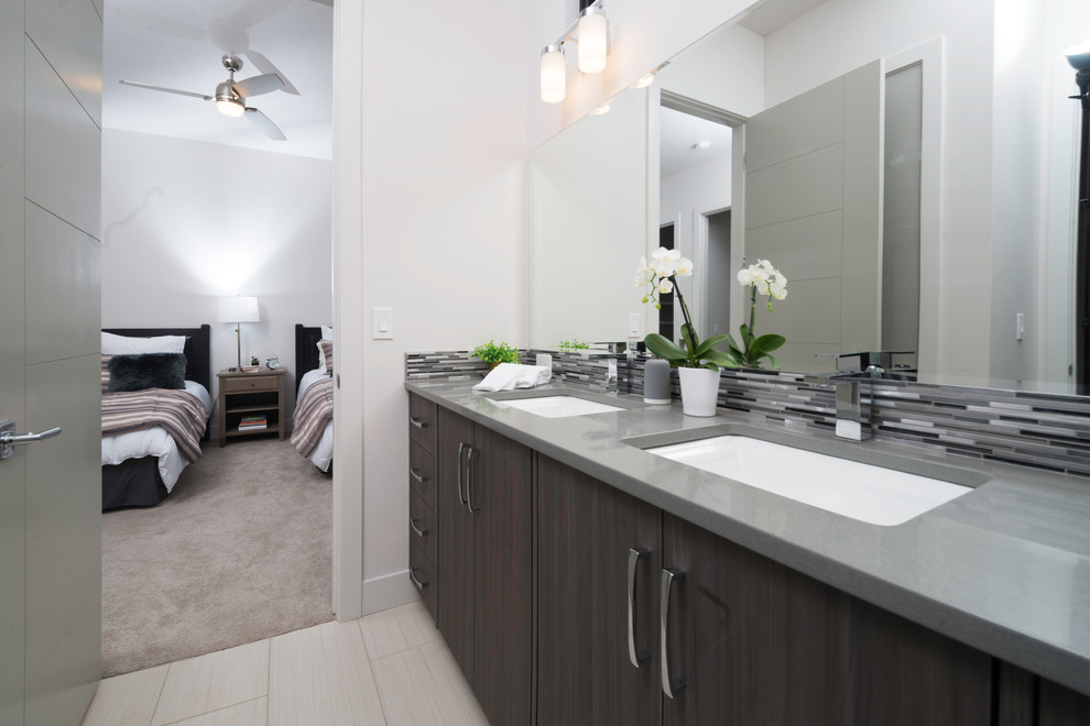 Exempel på ett stort modernt en-suite badrum, med släta luckor, skåp i mörkt trä, ett fristående badkar, svart och vit kakel, grå kakel, stickkakel, vita väggar, klinkergolv i keramik, ett undermonterad handfat och laminatbänkskiva