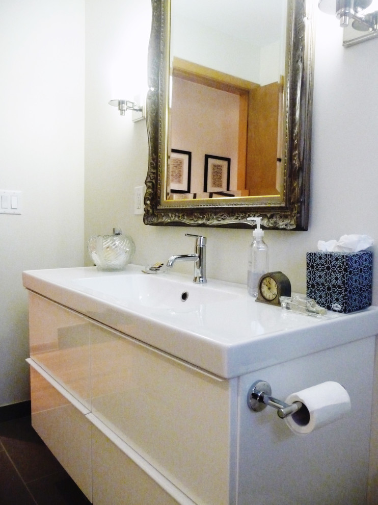 This is an example of a small eclectic shower room bathroom in Columbus with an integrated sink, flat-panel cabinets, white cabinets, an alcove shower, a one-piece toilet, white walls and ceramic flooring.
