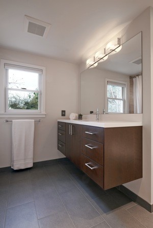 Inspiration for a mid-sized mid-century modern kids' gray tile and stone tile porcelain tile drop-in bathtub remodel in Seattle with flat-panel cabinets, quartz countertops, an undermount sink, white walls, dark wood cabinets and a two-piece toilet