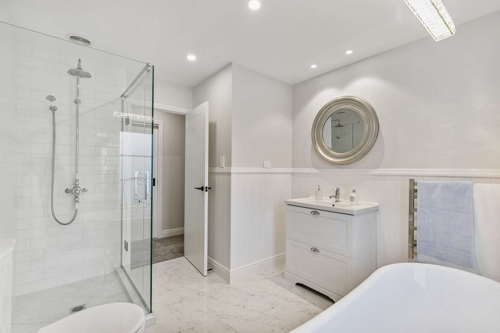 Idéer för ett mellanstort vit en-suite badrum, med skåp i shakerstil, vita skåp, en dusch i en alkov, en vägghängd toalettstol, vit kakel, keramikplattor, vita väggar, klinkergolv i keramik, ett integrerad handfat, laminatbänkskiva, flerfärgat golv och dusch med gångjärnsdörr