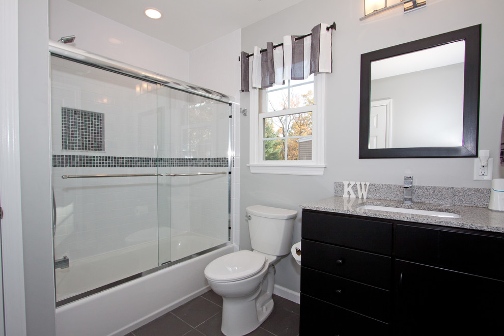 Example of a transitional 3/4 white tile and porcelain tile porcelain tile bathroom design in New York with an undermount sink, flat-panel cabinets, black cabinets, granite countertops and a two-piece toilet