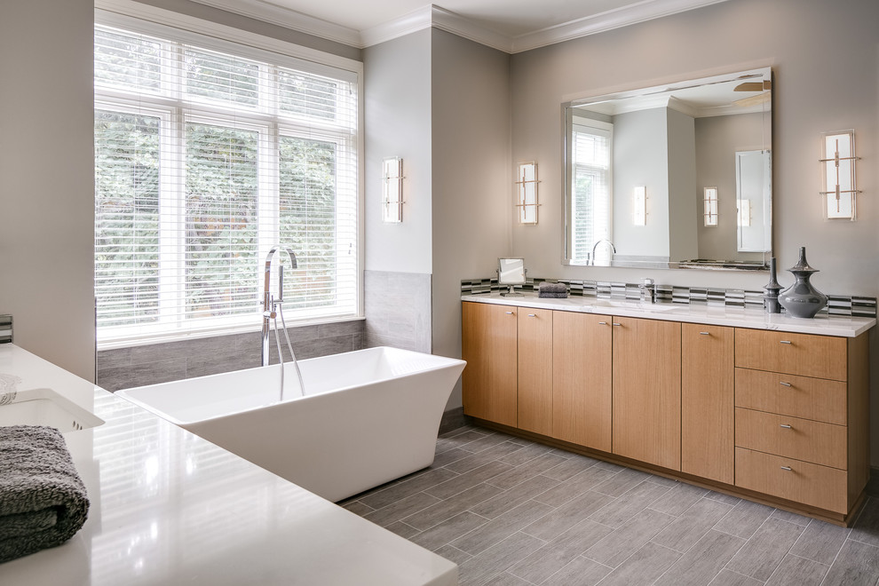 Inspiration for a mid-sized transitional master gray tile and glass sheet ceramic tile and gray floor bathroom remodel in Kansas City with flat-panel cabinets, light wood cabinets, a two-piece toilet, gray walls, an undermount sink, quartz countertops and a hinged shower door