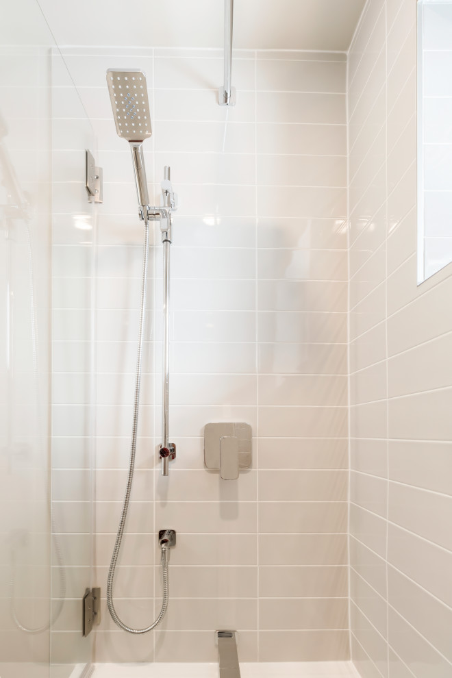 Свежая идея для дизайна: главная ванная комната среднего размера в современном стиле с стеклянными фасадами, белыми фасадами, ванной в нише, раздельным унитазом, серой плиткой, керамической плиткой, серыми стенами, полом из керамогранита, столешницей из искусственного кварца, серым полом, белой столешницей, нишей, тумбой под одну раковину и подвесной тумбой - отличное фото интерьера