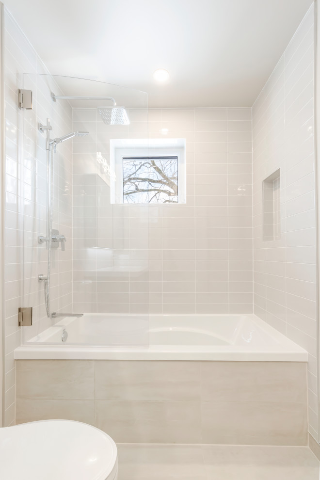 Idéer för att renovera ett mellanstort funkis vit vitt en-suite badrum, med luckor med glaspanel, vita skåp, ett badkar i en alkov, en toalettstol med separat cisternkåpa, grå kakel, keramikplattor, grå väggar, klinkergolv i porslin, bänkskiva i kvarts och grått golv