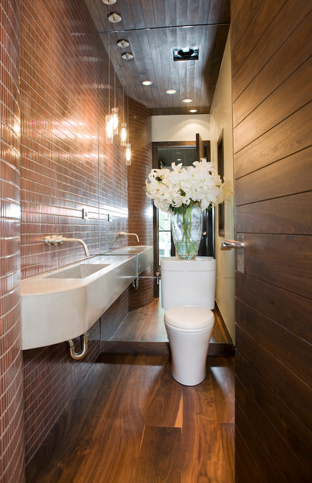 Idée de décoration pour une salle de bain longue et étroite design avec un lavabo suspendu et un carrelage marron.