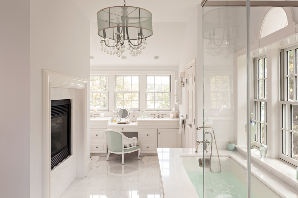 This is an example of a traditional bathroom in Boston with white tiles, stone tiles, white walls, marble flooring and a submerged bath.