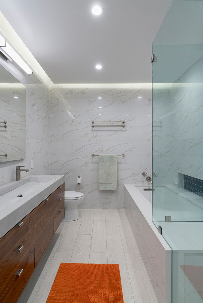 Inredning av ett modernt stort grå grått en-suite badrum, med släta luckor, skåp i mörkt trä, ett platsbyggt badkar, en öppen dusch, en toalettstol med hel cisternkåpa, vit kakel, keramikplattor, vita väggar, klinkergolv i keramik, ett integrerad handfat, bänkskiva i betong, vitt golv och dusch med gångjärnsdörr