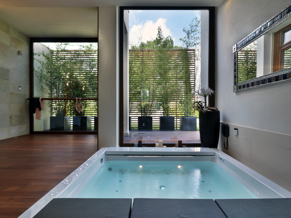 Modernes Badezimmer mit Whirlpool und braunem Holzboden in Bologna