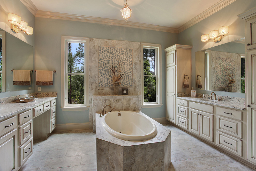 Idée de décoration pour une grande salle de bain principale tradition en bois vieilli avec un lavabo encastré, un placard avec porte à panneau surélevé, une baignoire posée et un mur bleu.