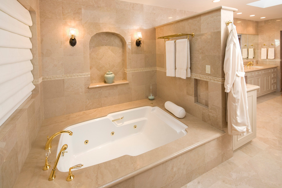 サンタバーバラにある高級な広い地中海スタイルのおしゃれなマスターバスルーム (一体型シンク、落し込みパネル扉のキャビネット、白いキャビネット、白いタイル、大型浴槽、ベージュの壁、大理石の床) の写真