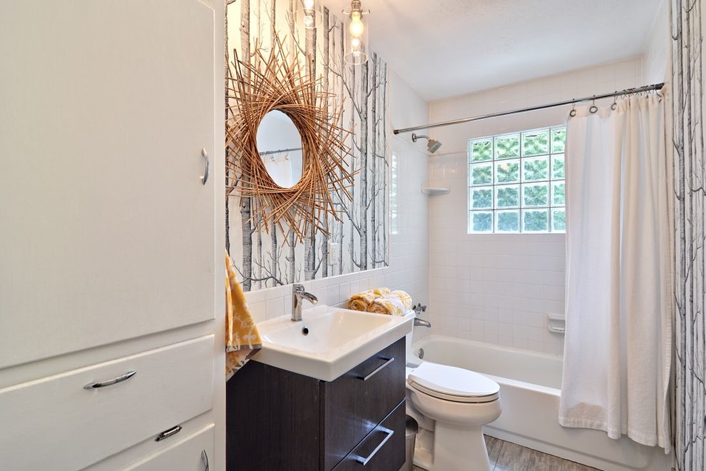 На фото: ванная комната в современном стиле с душем над ванной и шторкой для ванной с