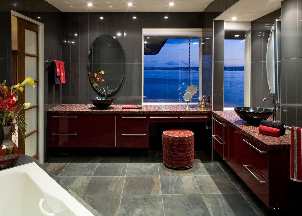 На фото: большая ванная комната в современном стиле с раковиной с несколькими смесителями, плоскими фасадами, красными фасадами, столешницей из плитки, накладной ванной, разноцветной плиткой, плиткой мозаикой, серыми стенами и полом из керамической плитки
