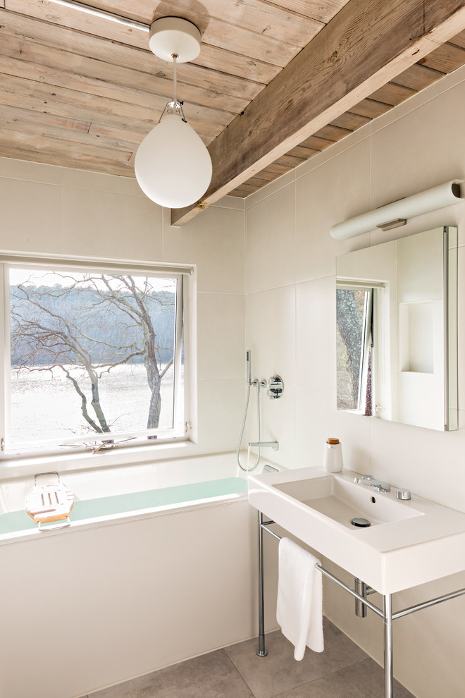 Modelo de cuarto de baño contemporáneo con bañera empotrada, baldosas y/o azulejos beige, paredes beige, aseo y ducha, lavabo tipo consola, suelo gris y encimeras blancas
