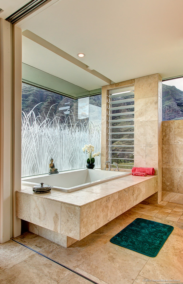 Ispirazione per una stanza da bagno tropicale con vasca da incasso, doccia aperta, piastrelle in pietra e pavimento in travertino