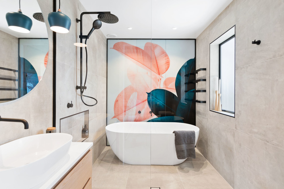 Design ideas for a contemporary ensuite bathroom in Auckland with flat-panel cabinets, light wood cabinets, a freestanding bath, a walk-in shower, grey tiles, cement tiles, grey walls, a vessel sink, beige floors, an open shower and white worktops.