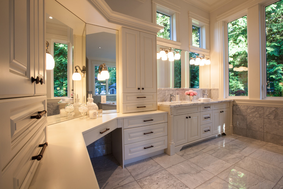 Expansive classic ensuite bathroom in Vancouver with a submerged sink, recessed-panel cabinets, white cabinets, marble worktops, a built-in bath, a corner shower, a one-piece toilet, grey tiles, stone slabs, white walls and marble flooring.