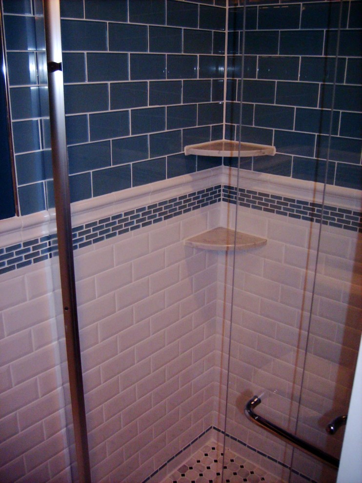 Cette image montre une petite salle de bain minimaliste avec un lavabo encastré, un placard avec porte à panneau encastré, des portes de placard noires, un plan de toilette en granite, WC séparés, un carrelage bleu, un carrelage en pâte de verre, un mur bleu et un sol en marbre.