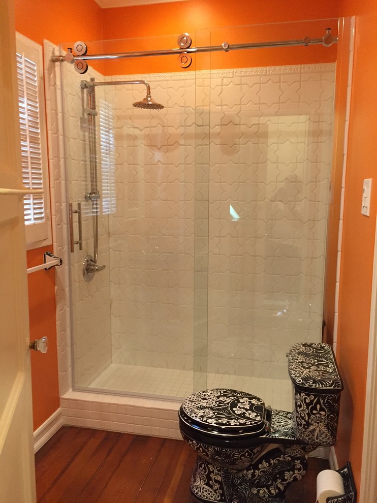 Inspiration för ett mellanstort eklektiskt badrum med dusch, med en dusch i en alkov, en toalettstol med separat cisternkåpa, vit kakel, keramikplattor, orange väggar, mörkt trägolv och ett piedestal handfat