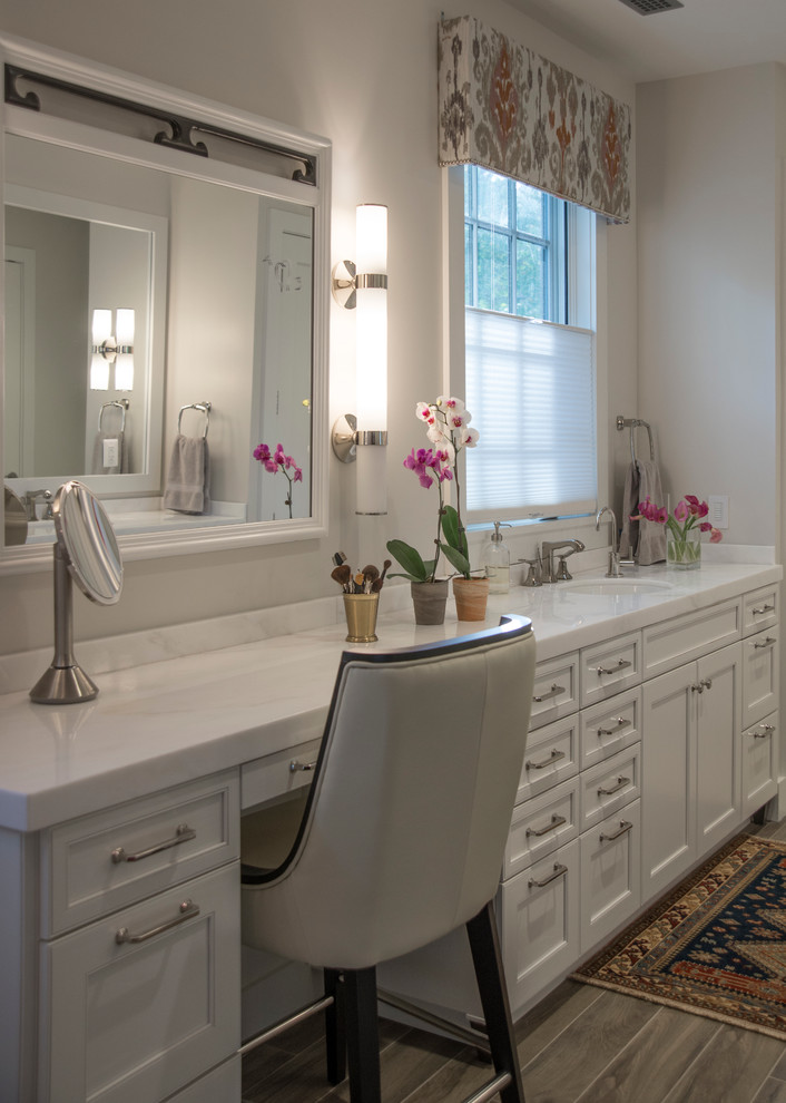 Diseño de cuarto de baño principal, tradicional renovado, grande, con lavabo bajoencimera, armarios tipo mueble, puertas de armario blancas, encimera de mármol, bañera exenta, paredes beige y suelo de baldosas de porcelana