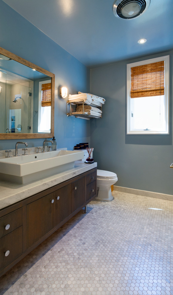 Foto di una grande stanza da bagno padronale tropicale con consolle stile comò, ante in legno bruno e vasca freestanding