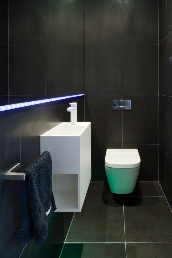 Idee per una stanza da bagno design con top in superficie solida, WC sospeso e piastrelle grigie