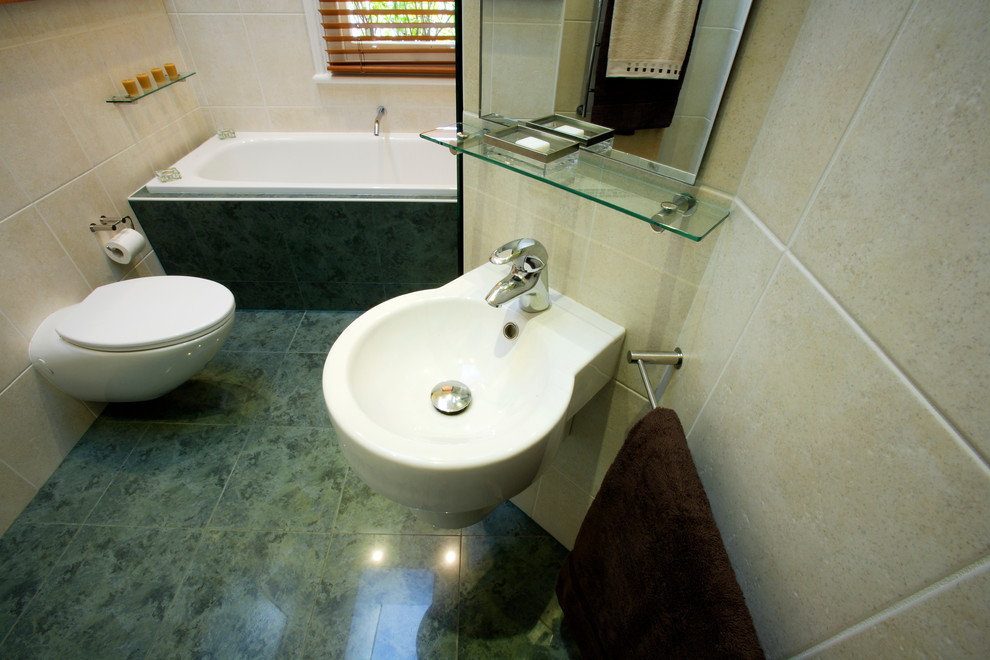 Exemple d'une petite salle d'eau chic en bois clair avec un lavabo de ferme, un placard à porte vitrée, un plan de toilette en verre, une baignoire posée, une douche ouverte, WC suspendus, un carrelage vert, des carreaux de porcelaine, un mur blanc et un sol en carrelage de porcelaine.