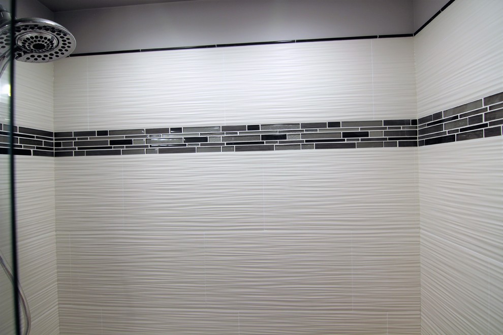 Пример оригинального дизайна: главная ванная комната среднего размера в стиле модернизм с фасадами с утопленной филенкой, белыми фасадами, унитазом-моноблоком, белой плиткой, керамической плиткой, серыми стенами, полом из керамической плитки, врезной раковиной, столешницей из гранита, серым полом и душем с раздвижными дверями