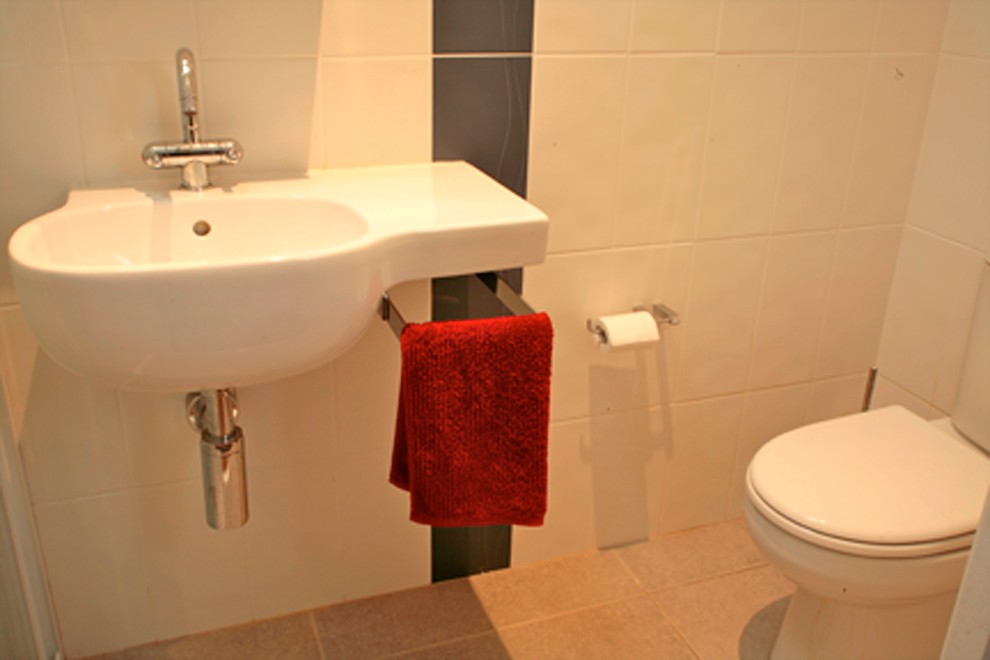 Esempio di una piccola stanza da bagno con doccia chic con lavabo sospeso, doccia aperta, piastrelle bianche, pareti bianche e pavimento in gres porcellanato