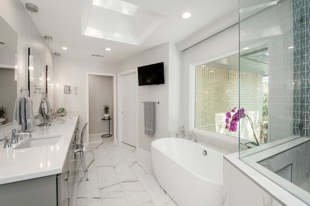 Example of a large transitional master gray tile and glass tile porcelain tile and white floor bathroom design in Dallas with flat-panel cabinets, gray cabinets, a one-piece toilet, gray walls, an undermount sink, quartz countertops and a hinged shower door