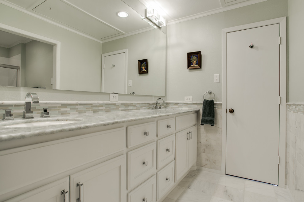 Réalisation d'une salle de bain principale design de taille moyenne avec un lavabo encastré, un placard à porte shaker, des portes de placard blanches, un plan de toilette en onyx, un combiné douche/baignoire, un carrelage blanc, un carrelage de pierre, un mur vert et un sol en marbre.