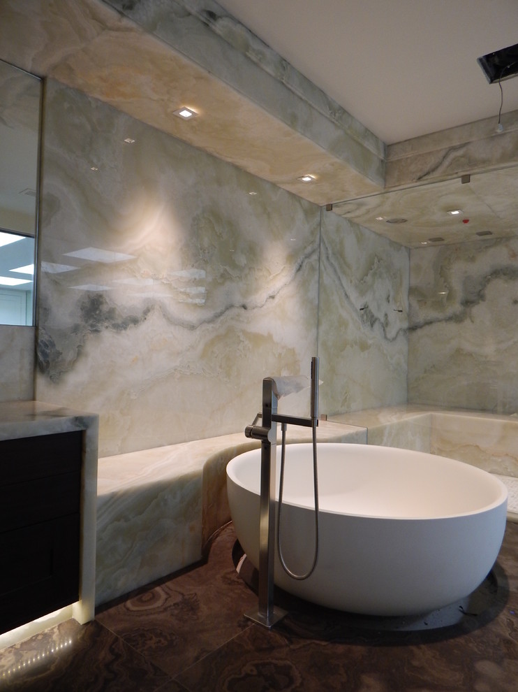 Свежая идея для дизайна: огромная главная ванная комната в современном стиле с темными деревянными фасадами, столешницей из оникса, открытым душем, коричневой плиткой и мраморным полом - отличное фото интерьера