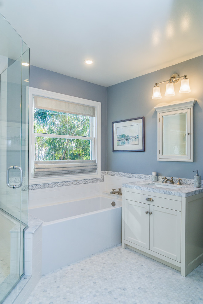 This is an example of a medium sized traditional bathroom in Los Angeles with recessed-panel cabinets, white cabinets, an alcove bath, a corner shower, white tiles, grey walls, marble flooring, a submerged sink, quartz worktops, metro tiles, white floors and a hinged door.