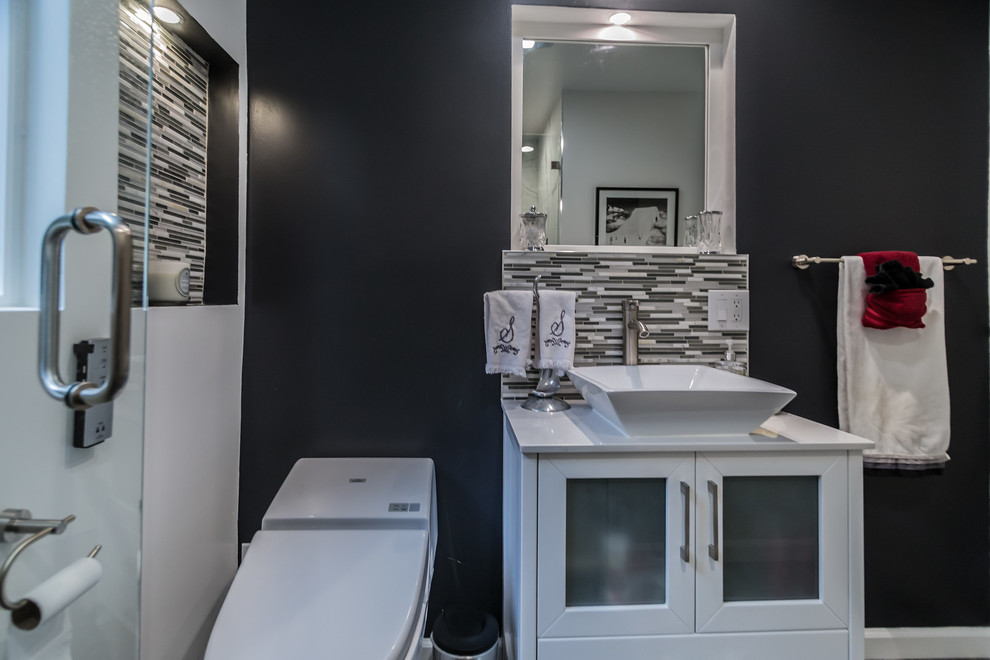 Immagine di una piccola sauna contemporanea con WC monopezzo, piastrelle multicolore, piastrelle a mosaico, pareti nere, lavabo a bacinella, pavimento con piastrelle a mosaico, ante di vetro e ante bianche