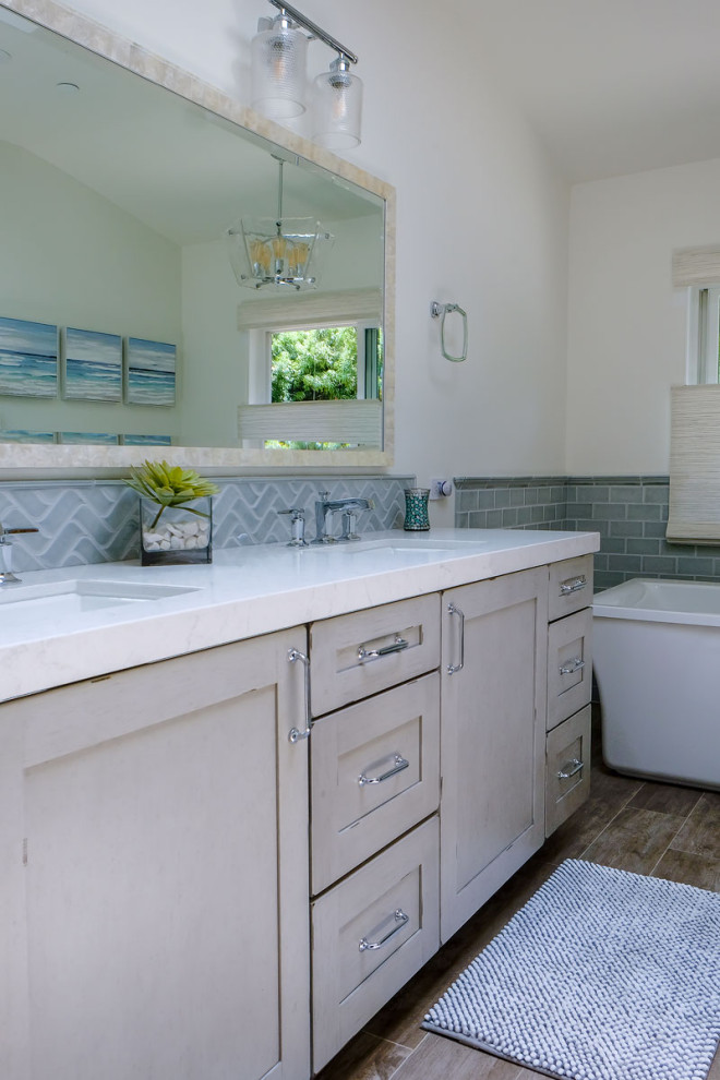 Large beach style master blue tile and porcelain tile porcelain tile, gray floor and double-sink bathroom photo in Los Angeles with shaker cabinets, distressed cabinets, a two-piece toilet, white walls, an undermount sink, quartz countertops, a hinged shower door, white countertops and a built-in vanity