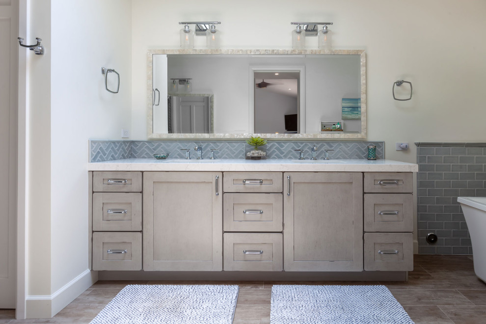Example of a large beach style master blue tile and porcelain tile porcelain tile, gray floor and double-sink bathroom design in Los Angeles with shaker cabinets, distressed cabinets, white walls, an undermount sink, quartz countertops, a hinged shower door, white countertops, a built-in vanity and a one-piece toilet