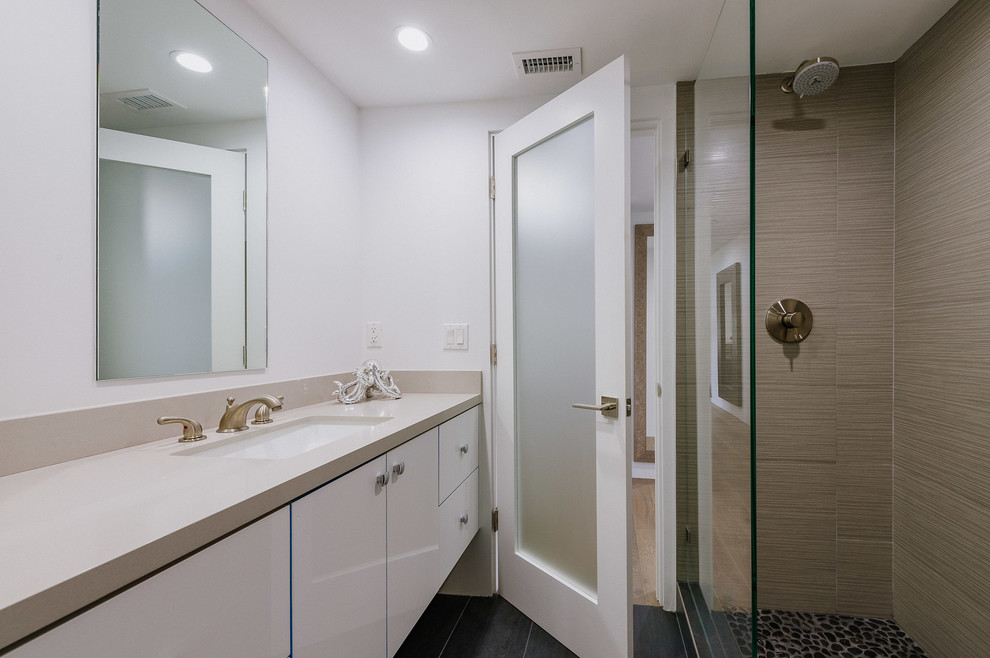 Inredning av ett modernt mellanstort badrum med dusch, med en öppen dusch, bänkskiva i akrylsten, med dusch som är öppen, släta luckor, vita skåp, klinkergolv i småsten och ett undermonterad handfat