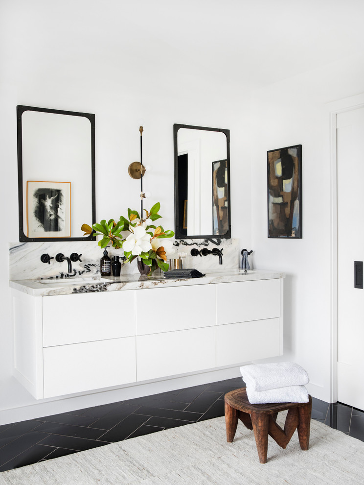 ロサンゼルスにあるコンテンポラリースタイルのおしゃれな浴室 (フラットパネル扉のキャビネット、白いキャビネット、白い壁、アンダーカウンター洗面器、黒い床、白い洗面カウンター) の写真