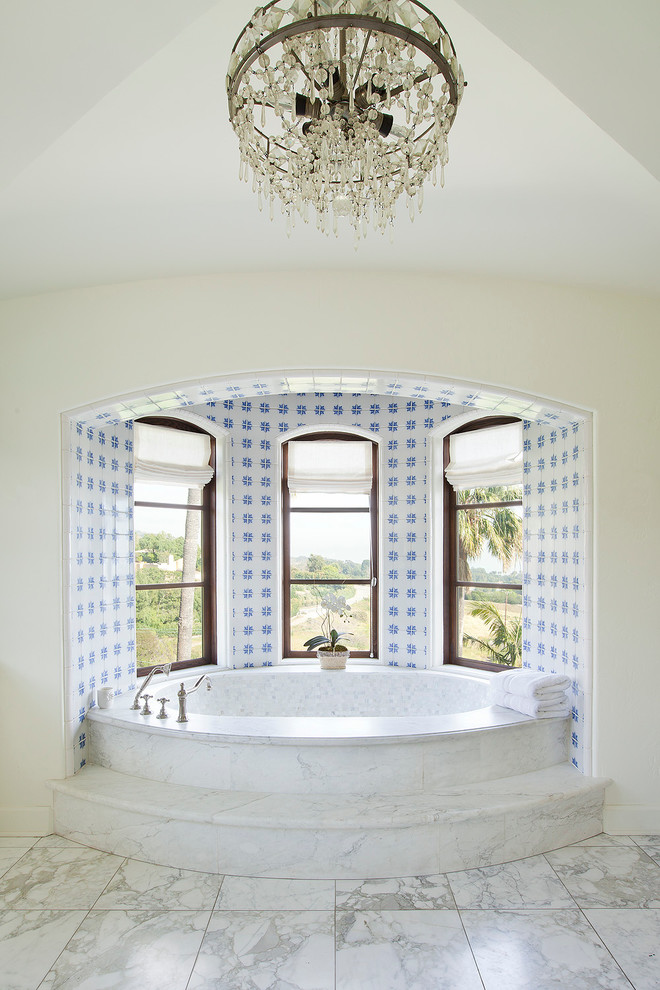 Medelhavsstil inredning av ett en-suite badrum, med ett badkar i en alkov, vita väggar och blå kakel