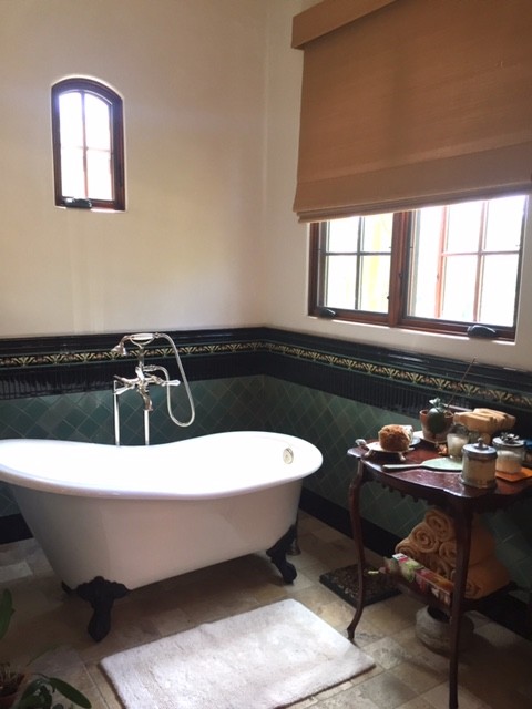 Exemple d'une grande salle de bain principale sud-ouest américain en bois vieilli avec un placard avec porte à panneau encastré, une baignoire sur pieds, une douche double, WC à poser, un carrelage vert, des carreaux de céramique, un mur blanc, un sol en marbre, un lavabo posé et un plan de toilette en marbre.