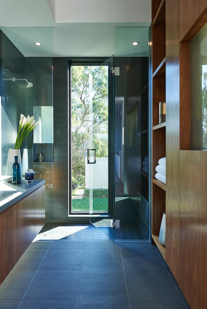 Photo of a large contemporary ensuite bathroom in Los Angeles with flat-panel cabinets, dark wood cabinets, an alcove shower, grey tiles, porcelain tiles, porcelain flooring, grey floors and a hinged door.