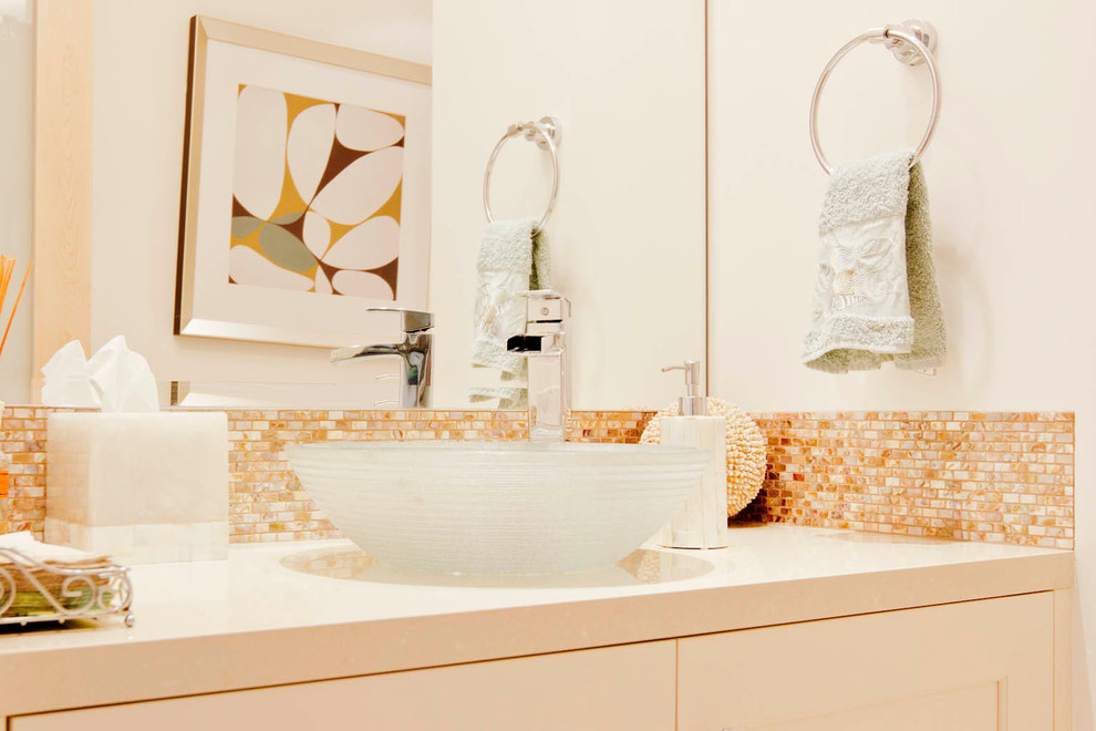 Cette photo montre une salle de bain tendance avec une vasque, un placard à porte shaker, des portes de placard blanches, un plan de toilette en quartz modifié, un mur blanc et un carrelage marron.