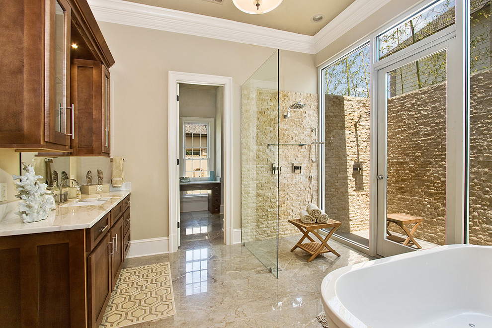 Inspiration for a transitional beige tile and stone tile beige floor bathroom remodel in New Orleans with an undermount sink, shaker cabinets and dark wood cabinets