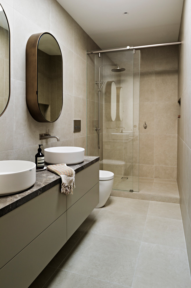 Diseño de cuarto de baño flotante contemporáneo con puertas de armario grises, lavabo sobreencimera y encimera de mármol