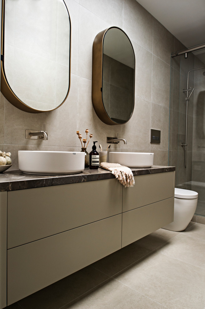 Exemple d'une salle de bain tendance avec des portes de placard grises, une vasque, un plan de toilette en marbre et meuble-lavabo suspendu.