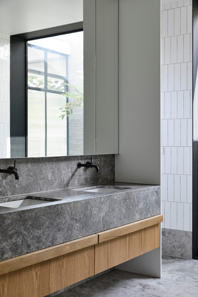 Exempel på ett mellanstort modernt grå grått en-suite badrum, med möbel-liknande, skåp i mellenmörkt trä, vit kakel, tunnelbanekakel, klinkergolv i keramik, ett undermonterad handfat, granitbänkskiva och grått golv